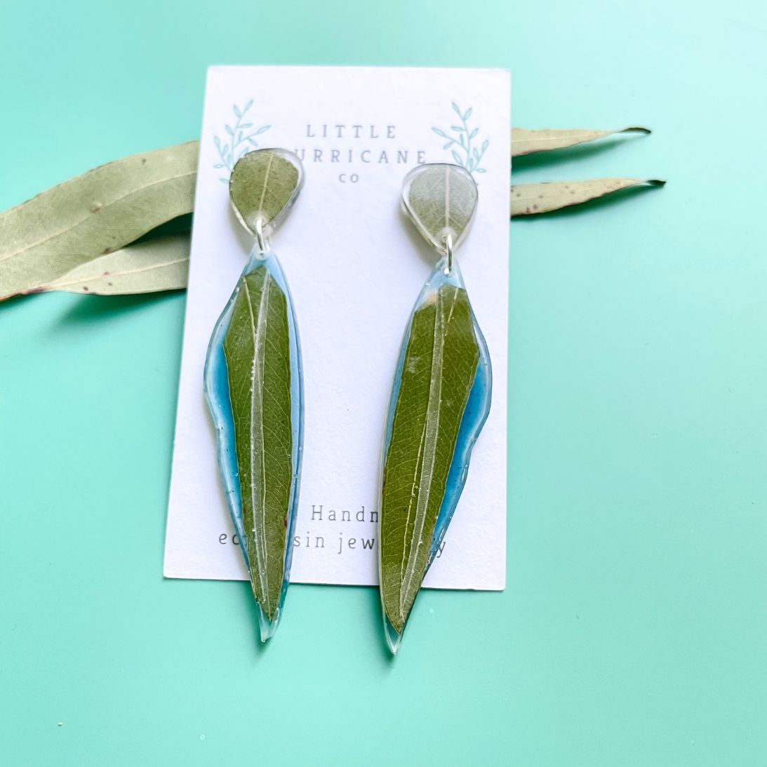 Eucalyptus leaf dangle earrings on blue